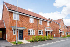 A red brick house with a blue door and windows.