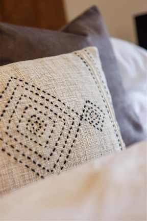 A pillow with a black design on a beige background.