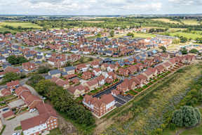 A bird's eye view of a residential area with houses and greenery.