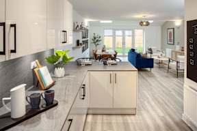 A modern kitchen with a dining area in the background.