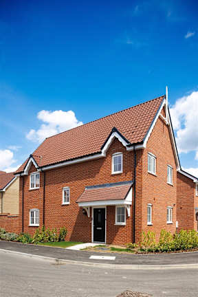A red brick house with a pitched roof and a front door.
