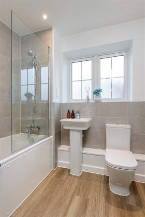 A white toilet sits next to a sink in a bathroom.