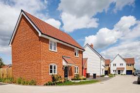 A red brick house with a white garage door in the front.