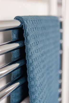 A blue towel is hanging on a metal rack.