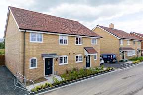 A row of houses with a van parked in the driveway.