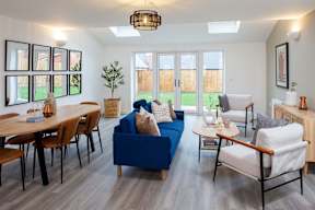 A living room with a blue couch and wooden furniture.