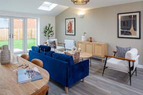 A blue sofa sits in a living room with a wooden table in front of it.