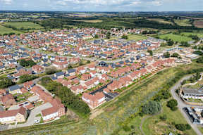 A bird's eye view of a residential area with houses and greenery.