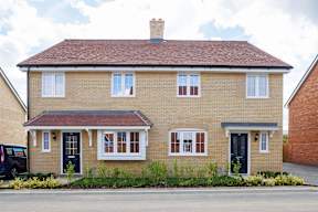 A two-story house with a brick facade and a black door.