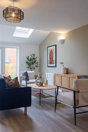 A living room with a blue couch and a wooden chair.