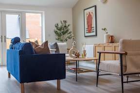 A blue sofa sits in a living room with a wooden coffee table and a chair.