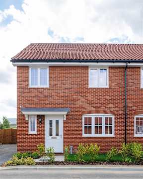 A red brick house with a white door and windows.