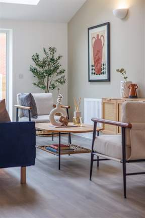 A living room with a blue chair and a white couch.