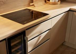 A modern kitchen with a cutting board on the counter.
