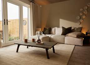 A living room with a white couch and a wooden coffee table.