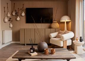 A living room with a white chair, a brown table, and a white lamp.