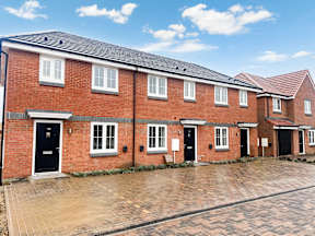 A row of red brick houses with black doors and windows.