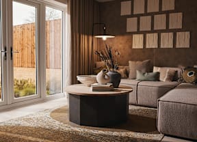 A modern living room with a round coffee table and a grey sofa.