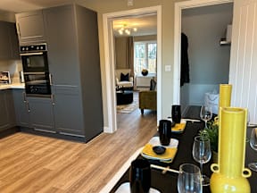 A modern kitchen with a dining table set for two.
