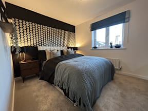 A bedroom with a bed, nightstand, and window.