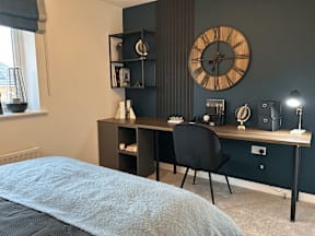 A bedroom with a bed, desk, and chair.