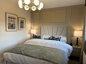 A bed with a white headboard and a green blanket is in the image.