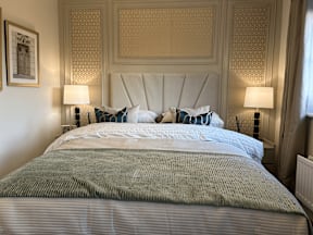 A bed with a white headboard and a grey blanket is in the image.