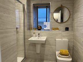 A bathroom with a sink, toilet, and mirror.
