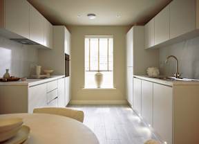 A kitchen with white cabinets and a table with plates on it.