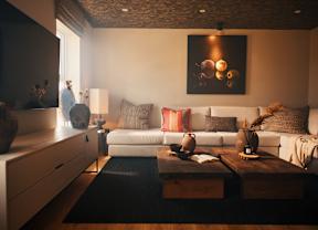 A living room with a white couch, a coffee table, and a painting on the wall.