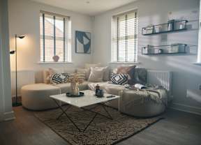 A living room with a white sofa, a white coffee table, and a rug on the floor.