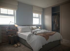 A bedroom with a large bed and a window.