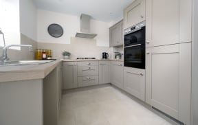 a kitchen with white cabinets and a sink and an oven