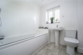 a white bathroom with a toilet sink and bath tub
