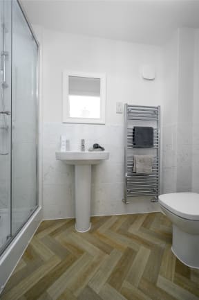 a small bathroom with a shower sink and toilet