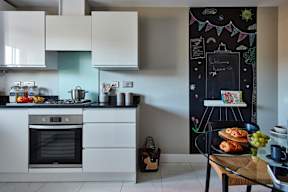 A kitchen with a chalkboard on the wall.