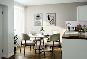 A modern dining room with a table set for two.