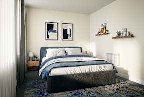 A bedroom with a large bed and a nightstand with a lamp.