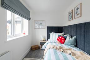 A bedroom with a bed, pillows, and a blanket.
