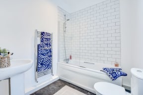 a white bathroom with a tub and a sink