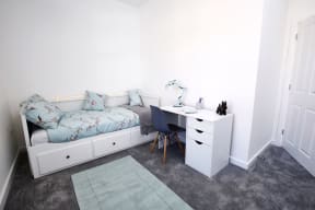 a small bedroom with a bed and a desk