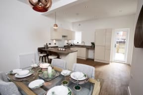 a dining room and kitchen with a table and chairs