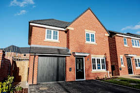 A red brick house with a black garage door.