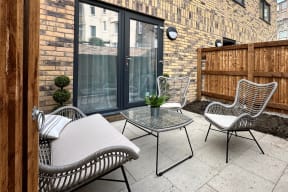 a patio with chairs and a table and a window