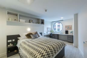 a bedroom with a bed and a desk in a room