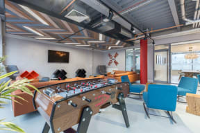 a game room with a foosball table and chairs