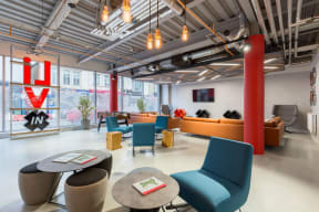 a lounge area with chairs and tables and a large window
