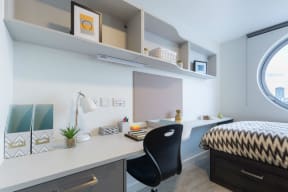 a bedroom with a desk and a bed