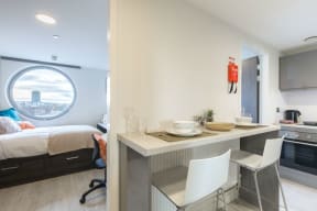 a bedroom and a kitchen with a bed and a window
