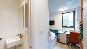 A small room with a bed, desk, and chair.